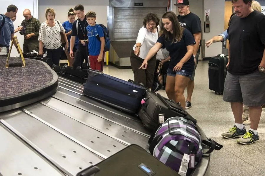 Travellers collecting luggage at a baggage claim carousel