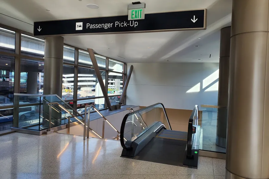 The escalator and stairs down to the Level 1 passenger pickup area