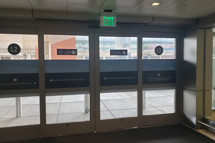 Sliding glass exit doors leading out to the passenger pickup curb